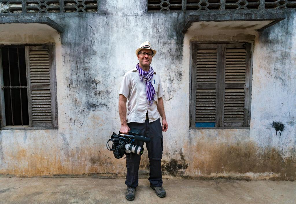 Chris G. Parkhurst holding a camera outside a building